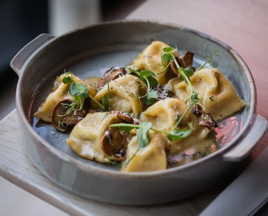 Pierożki z grzybami i parmezanem w glinianej miseczce