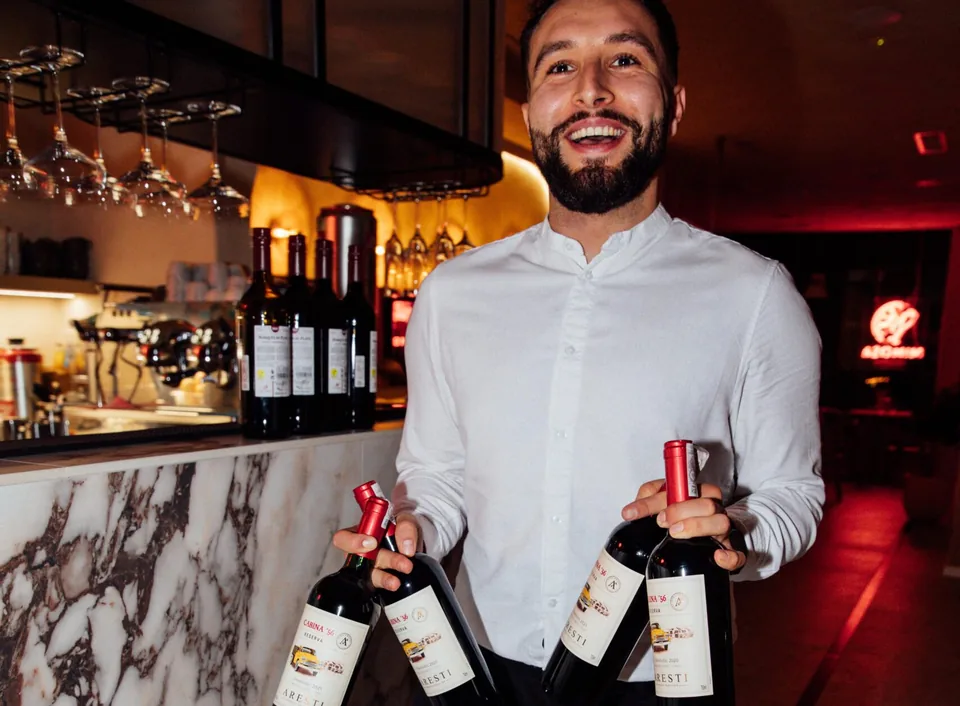 Kelner z butelkami wina przy barze w restauracji Mimosa w Gdańsku