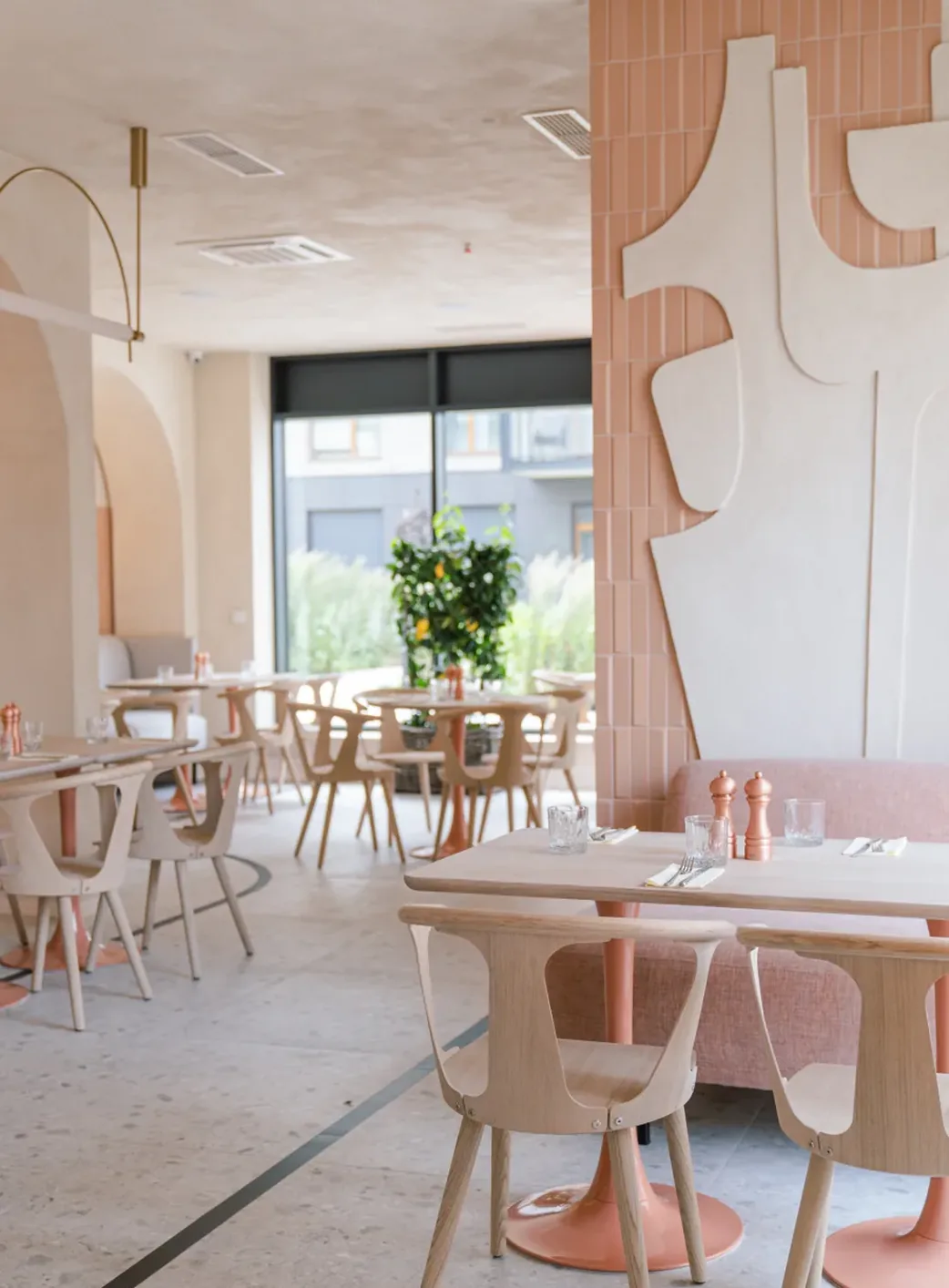 Jasne wnętrze restauracji Mimosa w Gdańsku Wrzeszczu z płaskorzeźbą na ścianie