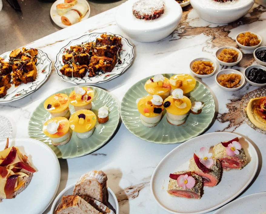 Cold starters and desserts on a marble table at a company dinner at Mimosa