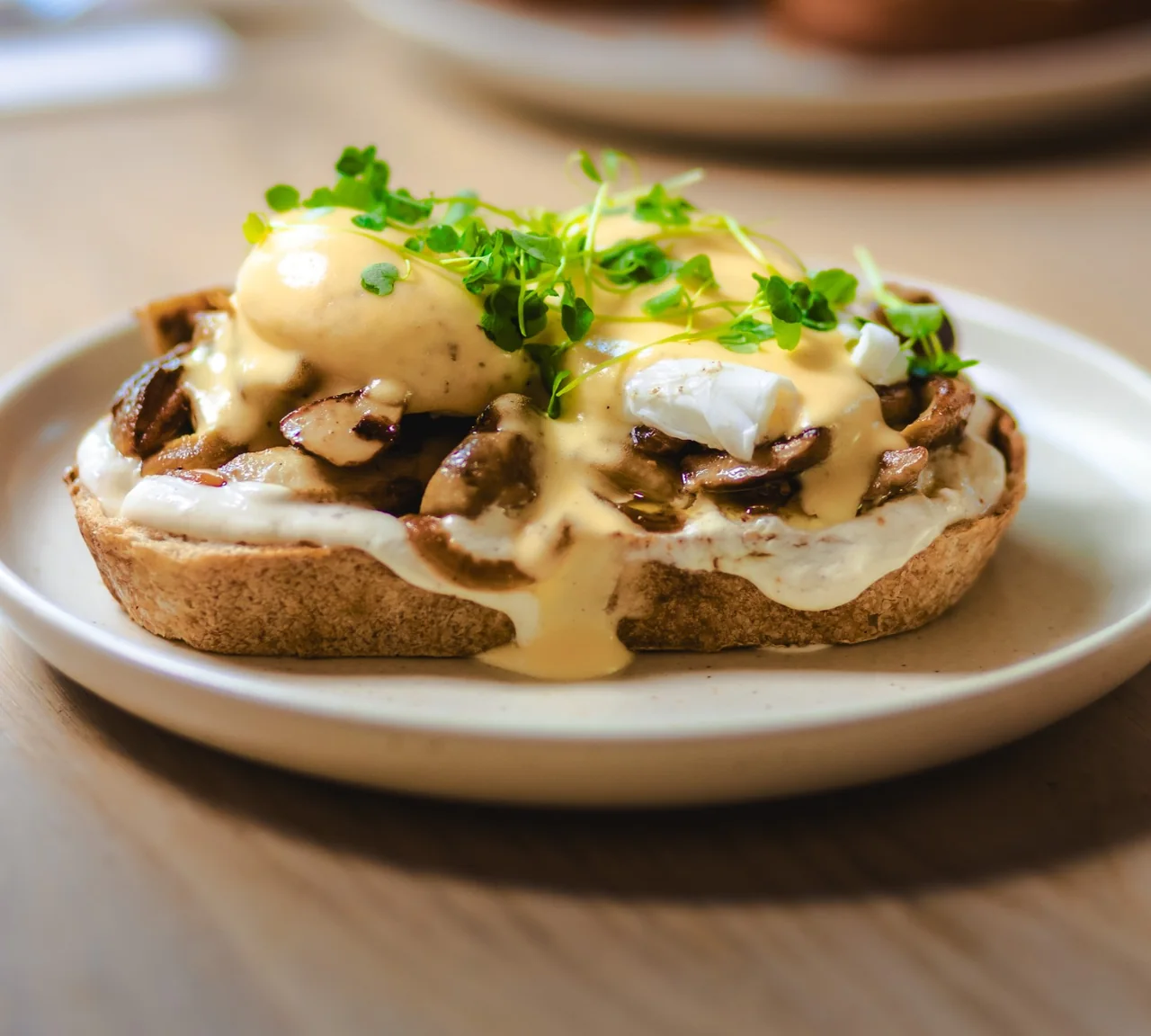 Eggs Benedict with wild mushrooms on sourdough, with hollandaise and micro herbs